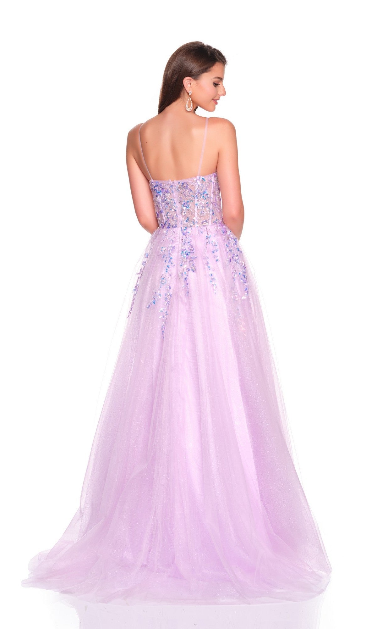 A woman faces away, wearing the Dave and Johnny 12762 long prom dressโa light purple gown with a tulle A-line skirt and floral embellishmentsโposed against a white background.